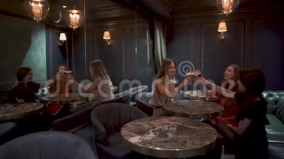 三个可爱的女孩坐在咖啡馆或餐馆里晚上过得愉快戴着一副可爱的眼镜微笑着心情很好视频的预览图