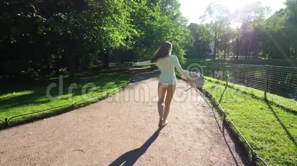 年轻女子在夏日公园闲逛享受生活理念视频的预览图