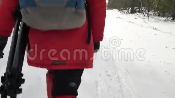 穿着防护靴背着大背包在雪地上行走的游客视频的预览图