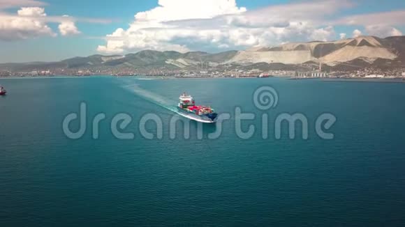 超大型集装箱船在海上蓝天和美丽的山脉背景下的鸟瞰图视频的预览图