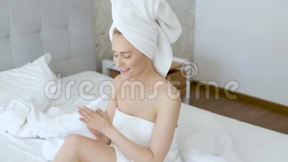 中年美丽的金发女人淋浴后滋润双腿视频的预览图