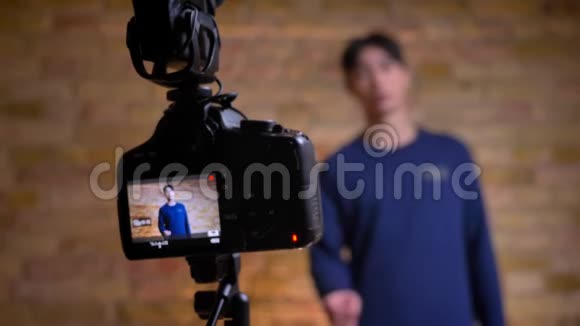 特写镜头录制韩国男性视频记录器的谈话然后重新聚焦于扬声器视频的预览图