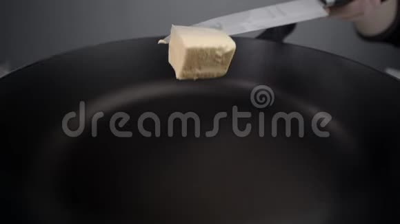 厨师在热锅上涂上黄油在锅上融化黄油刀端涂上黄油用牛奶烹饪视频的预览图