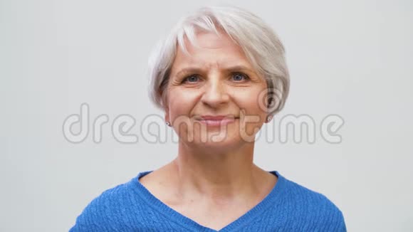 微笑的老妇人抚摸她头发的肖像视频的预览图