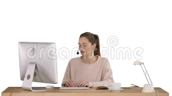 漂亮的年轻休闲女士戴着耳机在白色背景下工作在电脑上视频的预览图