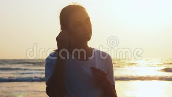 在海边慢跑之前女人正在准备耳机听音乐视频的预览图