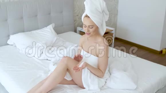 中年美丽的金发女人淋浴后滋润双腿视频的预览图