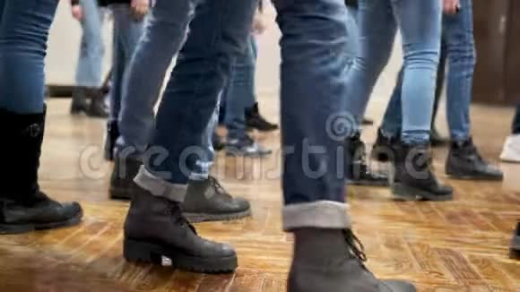 大群儿童同步穿着蓝色牛仔裤和黑色靴子跳舞培训视频的预览图