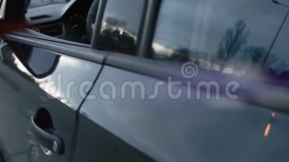 人坐在车里手握方向盘透过侧镜看着镜头慢动作视频的预览图