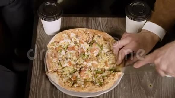 男人用刀把披萨切成碎片上景视频的预览图