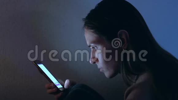 漂亮的女人晚上使用智能手机快关门视频的预览图