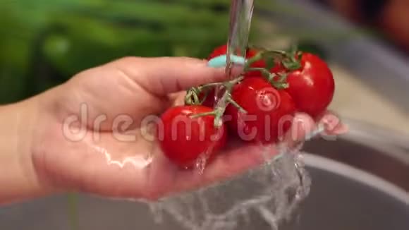一个女人在厨房的水槽里用水冲洗樱桃番茄视频的预览图