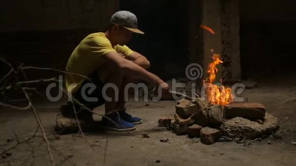一个人独自坐着看着燃烧的火焰视频的预览图
