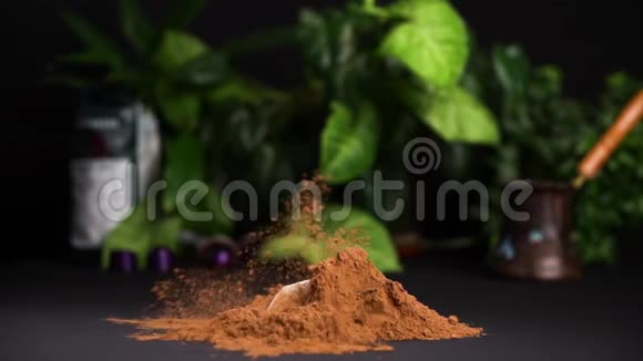 白色和黑色的巧克力碎片在黑色的桌子上缓慢地落入可可粉上面有漂亮的绿色植物视频的预览图