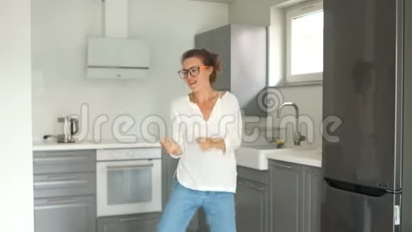 一位美丽的年轻女子在装修完成后的新厨房里跳舞的画像房地产维修视频的预览图