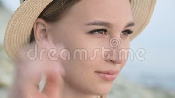 一个漂亮的白种人年轻女子戴着一顶草帽扎着辫子的大特写肖像使帽子挺直视频的预览图