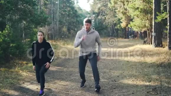 可爱的一对年轻人和他的女朋友一起在公园里做运动同时做运动视频的预览图