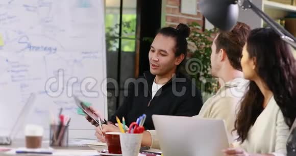 亚洲男人向亚洲女人展示他的平板电脑视频的预览图