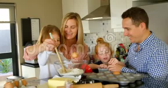 父母教孩子在厨房里准备面团视频的预览图