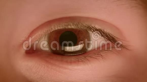 白种人棕色眼睛的特写镜头在暗光下缩小和扩大瞳孔视频的预览图
