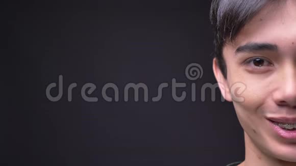 特写半脸的照片年轻迷人的韩国男性脸直视镜头微笑视频的预览图