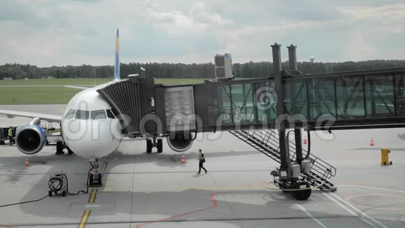降落在飞机上人们乘坐未被识别的航空公司通过喷气桥度假的概念视频的预览图