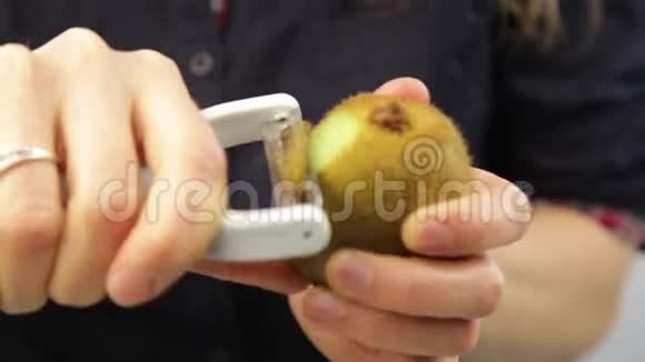 女人剥奇异果用专用刀将鲜猕猴桃切削皮闭合健康食品视频的预览图