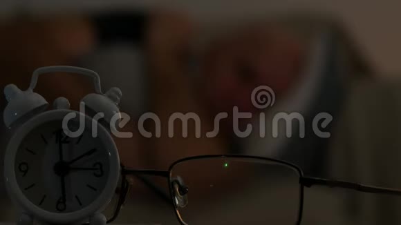 聚焦前景图像与闹钟和疲惫的人睡在后台视频的预览图
