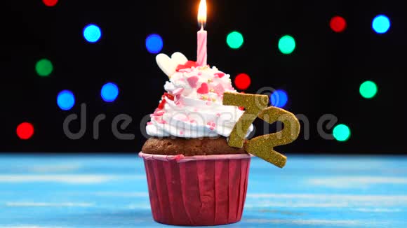 带有蜡烛的美味生日蛋糕和72号的彩色模糊灯光背景视频的预览图