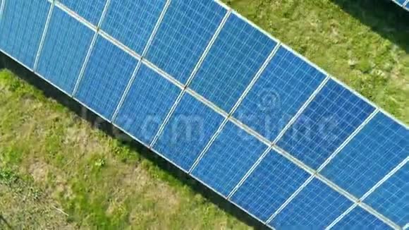 带有阳光的太阳能电池板农场太阳能电池的空中极端近景在太阳能电池板领域的无人机飞行视频的预览图
