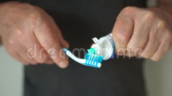 一只雄性的手把牙膏挤成牙刷专注于工具口腔卫生的概念视频的预览图