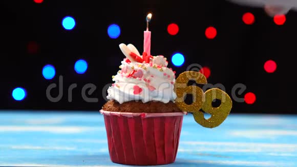 带有蜡烛的美味生日蛋糕和69号的彩色模糊灯光背景视频的预览图