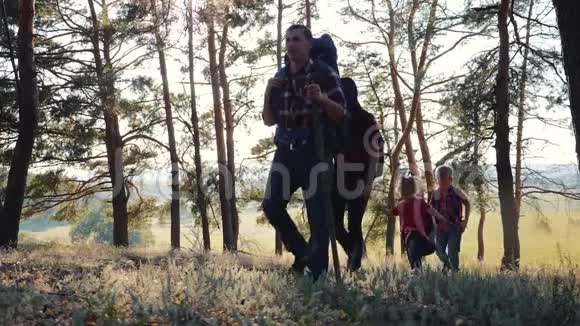 一个幸福的家庭家庭旅行和徒步穿越森林在日落露天行走团队合作健康视频的预览图