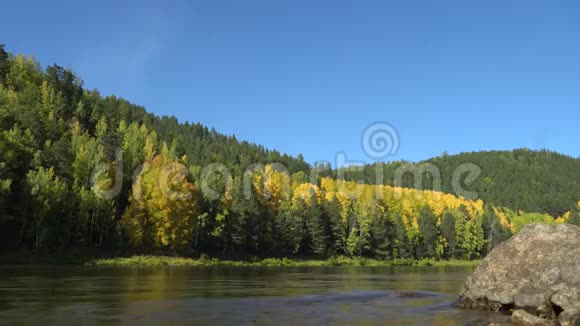 江岸秋日晴蓝天平静的河流和被森林覆盖的山脉视频的预览图