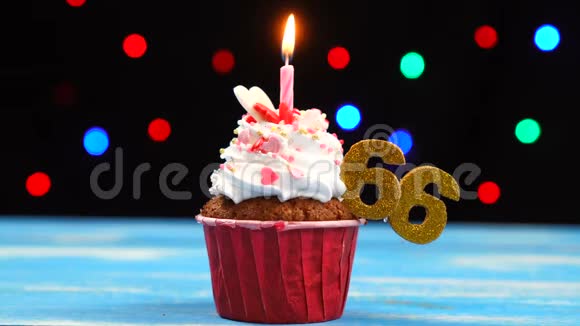 带有蜡烛的美味生日蛋糕和66号的彩色模糊灯光背景视频的预览图