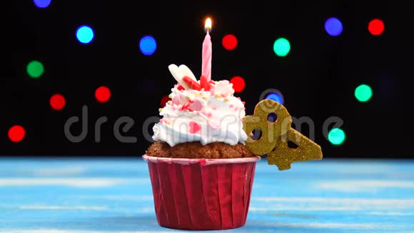 带有蜡烛的美味生日蛋糕和84号的彩色模糊灯光背景视频的预览图