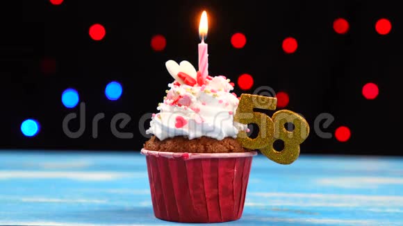 带有蜡烛的美味生日蛋糕和58号的彩色模糊灯光背景视频的预览图