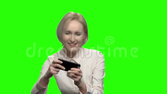 中年女商人在手机上玩电子游戏视频的预览图