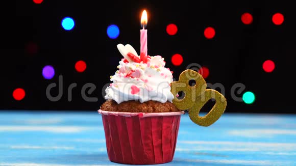 带有蜡烛的美味生日蛋糕和80号的彩色模糊灯光背景视频的预览图