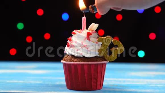 美味的生日纸杯蛋糕在五彩缤纷的迷离灯光背景下点着蜡烛和数字13视频的预览图