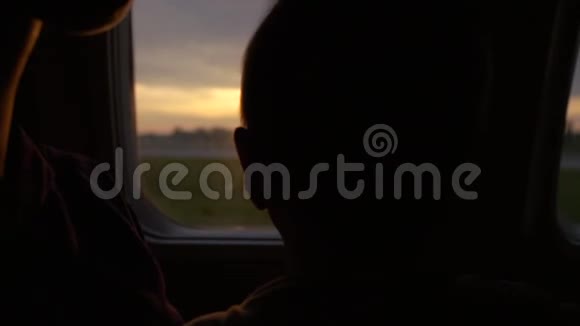 女孩和她的儿子在起飞时看着飞机的窗户慢动作视频的预览图