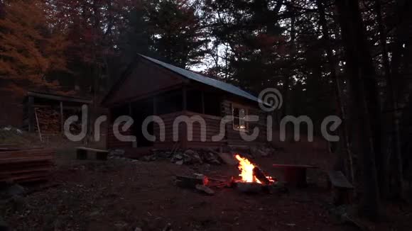 动作缓慢在木屋的背景下晚上在泰加燃烧篝火秋景视频的预览图