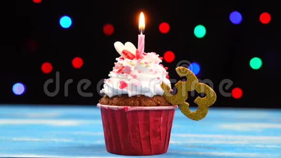 带有蜡烛的美味生日蛋糕还有33号的彩色模糊灯光背景视频的预览图