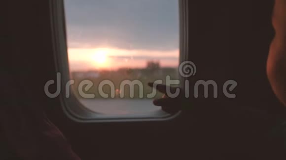 这个男孩缓慢地透过飞机的窗户看太阳升起视频的预览图