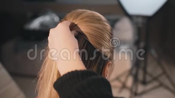 美容师化妆师发型白人模特金发使用梳子和清漆把头发的尾巴结起来视频的预览图