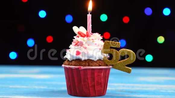 带有蜡烛的美味生日蛋糕和52号的彩色模糊灯光背景视频的预览图