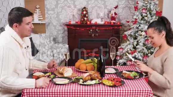 一对夫妇在圣诞晚餐桌上吃着香槟碰着酒杯视频的预览图