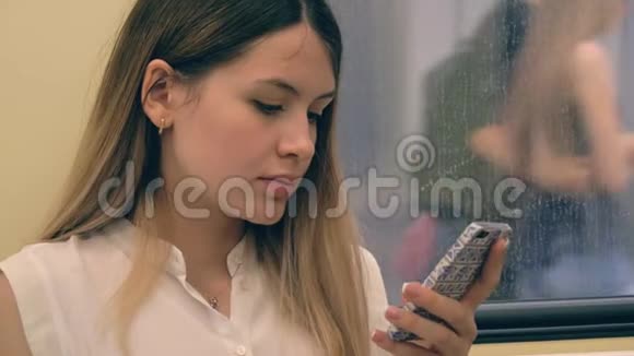 年轻白人女性乘坐地铁和使用智能手机的画像视频的预览图