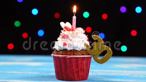 带有蜡烛的美味生日蛋糕和30号的彩色模糊灯光背景视频的预览图