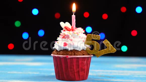 带有蜡烛的美味生日蛋糕和57号的彩色模糊灯光背景视频的预览图